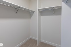 Wall-to-wall carpeting, white shelving, and hanging rods - 