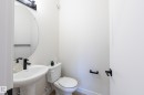 Pedestal sink with a matte black faucet, wall-mounted oval mirror, and contemporary black vanity light - 6306 65 Ave, Beaumont, AB 