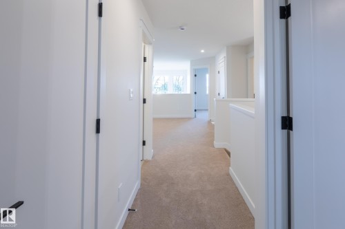 Hallway featuring light-toned carpeting, white walls, and recessed lighting - 6306 65 Ave, Beaumont, AB 