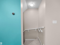 Carpeted staircase with white handrail and neutral wall paint - 