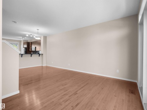 Wood-finish flooring throughout, light neutral wall tones, and recessed lighting - #162 603 Watt Bv Sw, Edmonton, AB 