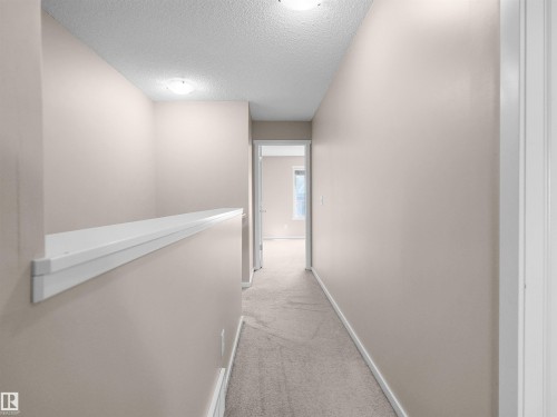 Carpeted hallway with neutral wall paint and overhead lighting - #162 603 Watt Bv Sw, Edmonton, AB 