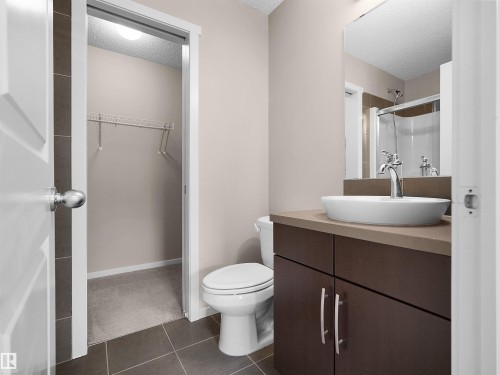 Bathroom with a vessel sink, dark wood-finish vanity, and a chrome faucet - #162 603 Watt Bv Sw, Edmonton, AB 