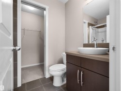 Bathroom with a vessel sink, dark wood-finish vanity, and a chrome faucet - 