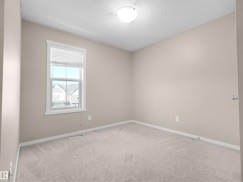 Neutral-toned walls, plush carpeting, and a window with white blinds - #162 603 Watt Bv Sw, Edmonton, AB 