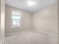 Neutral-toned walls, plush carpeting, and a window with white blinds - 