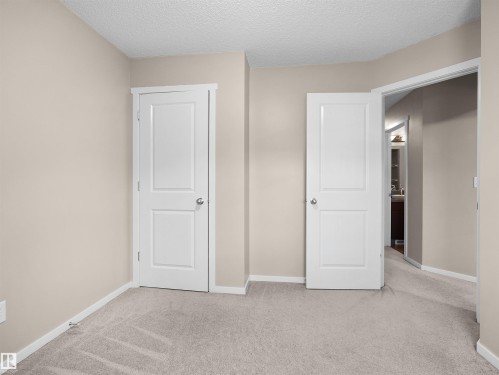 Light-colored carpeting, neutral wall paint, white trim, and paneled interior doors - #162 603 Watt Bv Sw, Edmonton, AB 