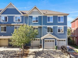 Blue siding exterior with white window trim, multiple windows, and two attached garages - 