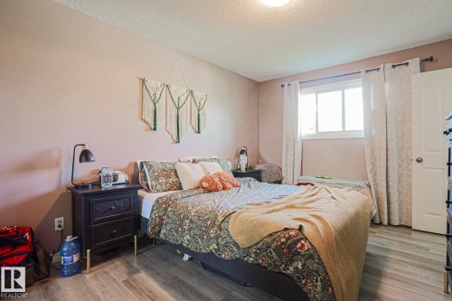 Light wood-finish flooring with a white trim window and white door - 21 Burlington Avenue, Spruce Grove, AB 