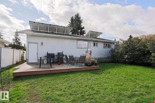 Rear exterior with solar panels, a wooden deck, and a grass lawn - 21 Burlington Avenue, Spruce Grove, AB 