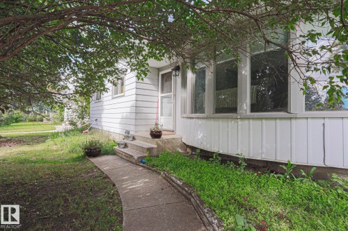 Curved concrete walkway leading to a concrete front porch with two steps - 21 Burlington Avenue, Spruce Grove, AB 