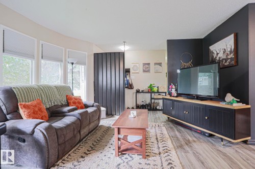 Wood-finish flooring, accent wall, and multiple windows with blinds - 21 Burlington Avenue, Spruce Grove, AB 