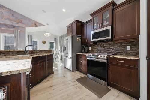 Kitchen with SS appliances, quartz countertops & large island with breakfast nook & sink - 10819 175 Avenue Nw, Edmonton, AB 