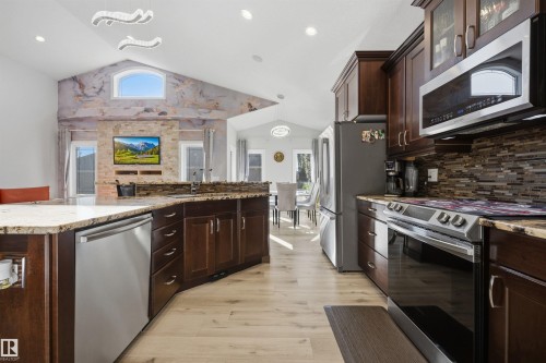 Kitchen with SS appliances, quartz countertops & large island with breakfast nook & sink - 10819 175 Avenue Nw, Edmonton, AB 