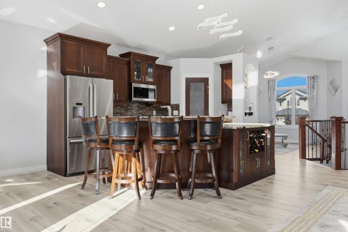Kitchen with SS appliances, quartz countertops & large island with breakfast nook & sink - 10819 175 Avenue Nw, Edmonton, AB 