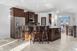 Kitchen with SS appliances, quartz countertops & large island with breakfast nook & sink - 