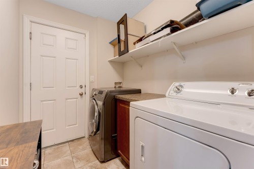 Light-colored tile flooring, solid panel interior door, built-in shelving, and countertop space - 3012 25 Ave Avenue Nw, Edmonton, AB 