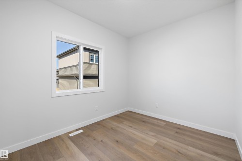 White walls, wood-finish flooring, white window frame, and white baseboards - 960 Elderberry Landing Nw, Edmonton, AB 