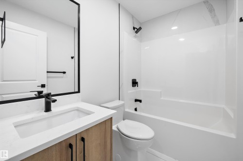 Bathroom featuring a vanity with wood-finish cabinetry, a white countertop, and a rectangular undermount sink - 960 Elderberry Landing Nw, Edmonton, AB 