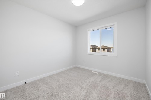 Neutral wall paint, light-toned carpet, white trim, and a flush-mount ceiling light - 960 Elderberry Landing Nw, Edmonton, AB 