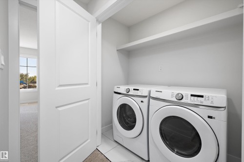Dedicated laundry space featuring a built-in shelf and white tile flooring - 960 Elderberry Landing Nw, Edmonton, AB 