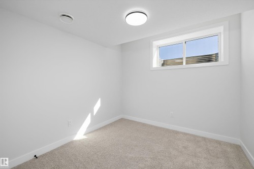 Neutral-toned wall-to-wall carpeting, white painted walls, and a white-trimmed window - 960 Elderberry Landing Nw, Edmonton, AB 