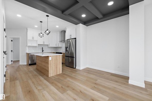 Open-concept living space with wood-finish flooring, a coffered ceiling, and recessed lighting - 960 Elderberry Landing Nw, Edmonton, AB 