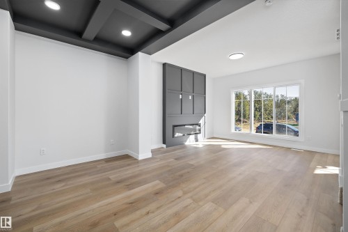 Wood-finish flooring, large multi-pane window, built-in electric fireplace, coffered ceiling, recessed lighting - 960 Elderberry Landing Nw, Edmonton, AB 