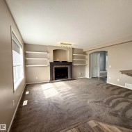 Living area featuring a fireplace with a dark wood mantel and surround, built-in shelving, and carpeting - 