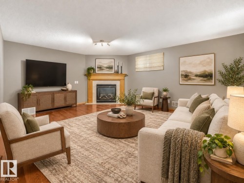 Hardwood flooring throughout, a gas fireplace with a wood mantel, and recessed lighting fixtures - 1271 Ormsby Lane Nw, Edmonton, AB 