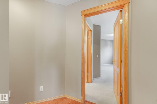 Warm wood-finish flooring with light-toned walls - 1271 Ormsby Lane Nw, Edmonton, AB 