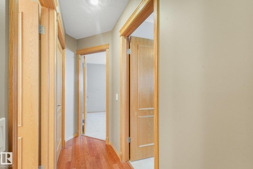 Hallway with wood-finish flooring, light-toned walls, and recessed lighting - 1271 Ormsby Lane Nw, Edmonton, AB 