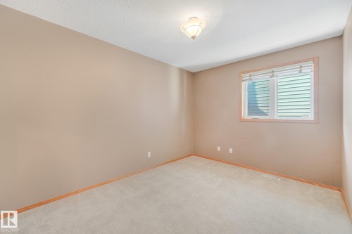 Neutral-toned walls, carpeted flooring, and a single window with horizontal blinds - 1271 Ormsby Lane Nw, Edmonton, AB 