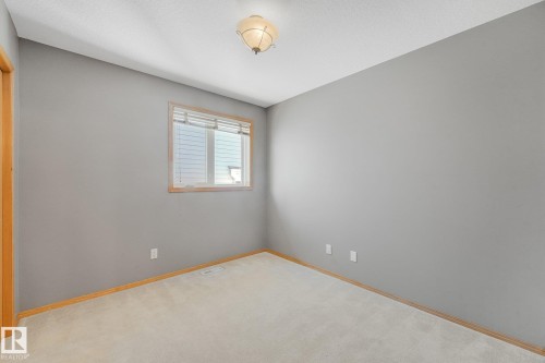 Wall-to-wall carpeting, neutral wall color, and a single window with wood-finish trim - 1271 Ormsby Lane Nw, Edmonton, AB 