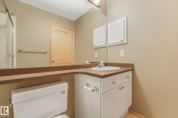 Bathroom featuring a neutral palette, white vanity with integrated sink, and an expansive wall-mounted mirror - 