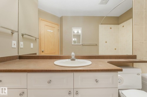 Vanity with an integrated sink, brown countertop, and white cabinetry - 1271 Ormsby Lane Nw, Edmonton, AB 