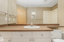 Vanity with an integrated sink, brown countertop, and white cabinetry - 