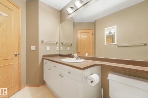 Light wood-panel door, vanity with white cabinetry, integrated sink, and an expansive countertop - 1271 Ormsby Lane Nw, Edmonton, AB 