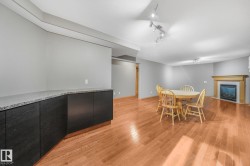 Wood-finish flooring, built-in cabinetry with stone countertop, recessed lighting, and a fireplace with a wood-finished mantel - 