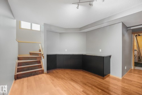 Wood-finish flooring, built-in cabinetry with a countertop, recessed lighting, and a staircase with wood-finish risers - 1271 Ormsby Lane Nw, Edmonton, AB 