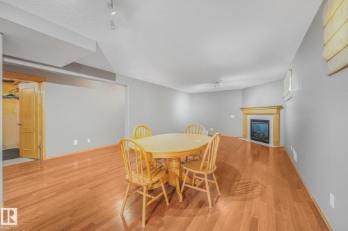 Hardwood flooring throughout, recessed lighting, and a corner fireplace with a wood-finish mantel - 1271 Ormsby Lane Nw, Edmonton, AB 