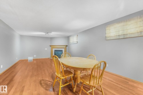 Wood-finish flooring, recessed fireplace with wood mantel, and window treatments - 1271 Ormsby Lane Nw, Edmonton, AB 