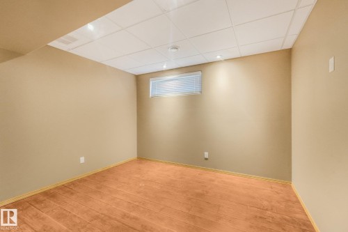 Wood-finish flooring, drop ceiling with recessed lighting, and an egress window with blinds - 1271 Ormsby Lane Nw, Edmonton, AB 