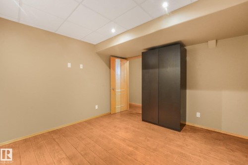 Wood-finish flooring, recessed lighting, drop ceiling, light-toned walls, and a wood-panel door - 1271 Ormsby Lane Nw, Edmonton, AB 