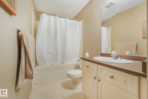 Bathroom with a vanity featuring a built-in sink, an integrated mirror, and storage cabinetry - 1271 Ormsby Lane Nw, Edmonton, AB 