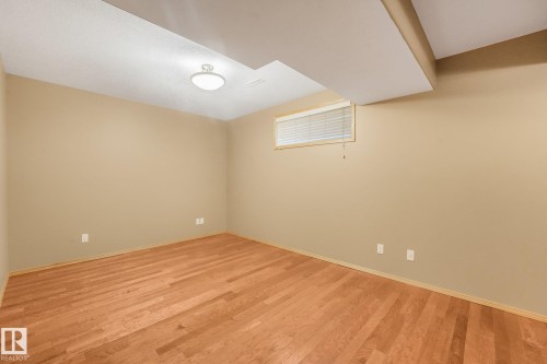 Hardwood flooring, neutral wall tones, flush-mount ceiling lighting, and a single window with blinds - 1271 Ormsby Lane Nw, Edmonton, AB 