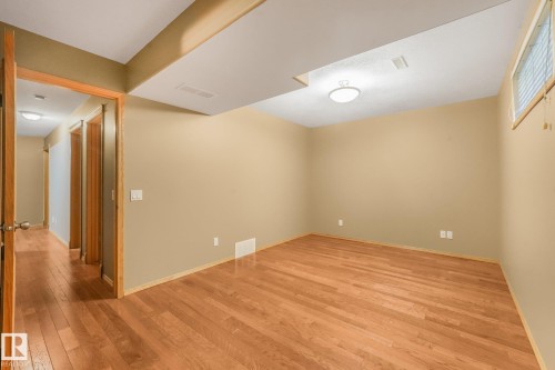Wood-finish flooring, recessed ceiling beam, flush-mount ceiling light, single window with blinds, and neutral wall tones - 1271 Ormsby Lane Nw, Edmonton, AB 