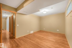 Wood-finish flooring, recessed ceiling beam, flush-mount ceiling light, single window with blinds, and neutral wall tones - 