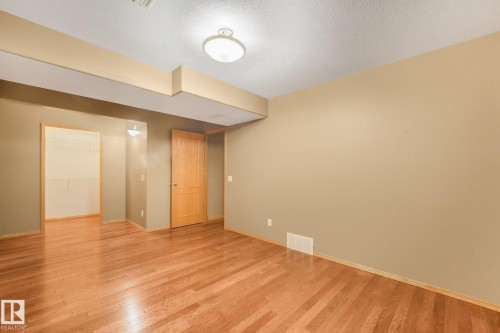 Wood-finish flooring throughout, neutral tone walls, recessed ceiling feature, and a flush-mount ceiling light fixture - 1271 Ormsby Lane Nw, Edmonton, AB 