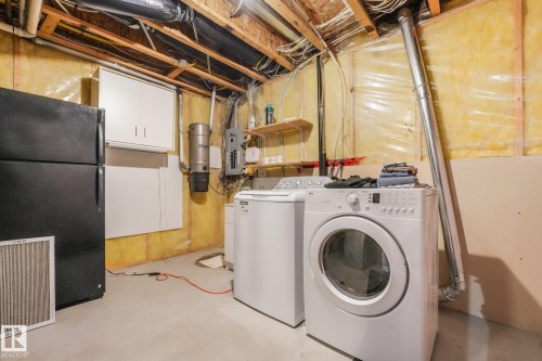 Laundry area featuring a washer and dryer, exposed ceiling joists, and a central vacuum system - 1271 Ormsby Lane Nw, Edmonton, AB 